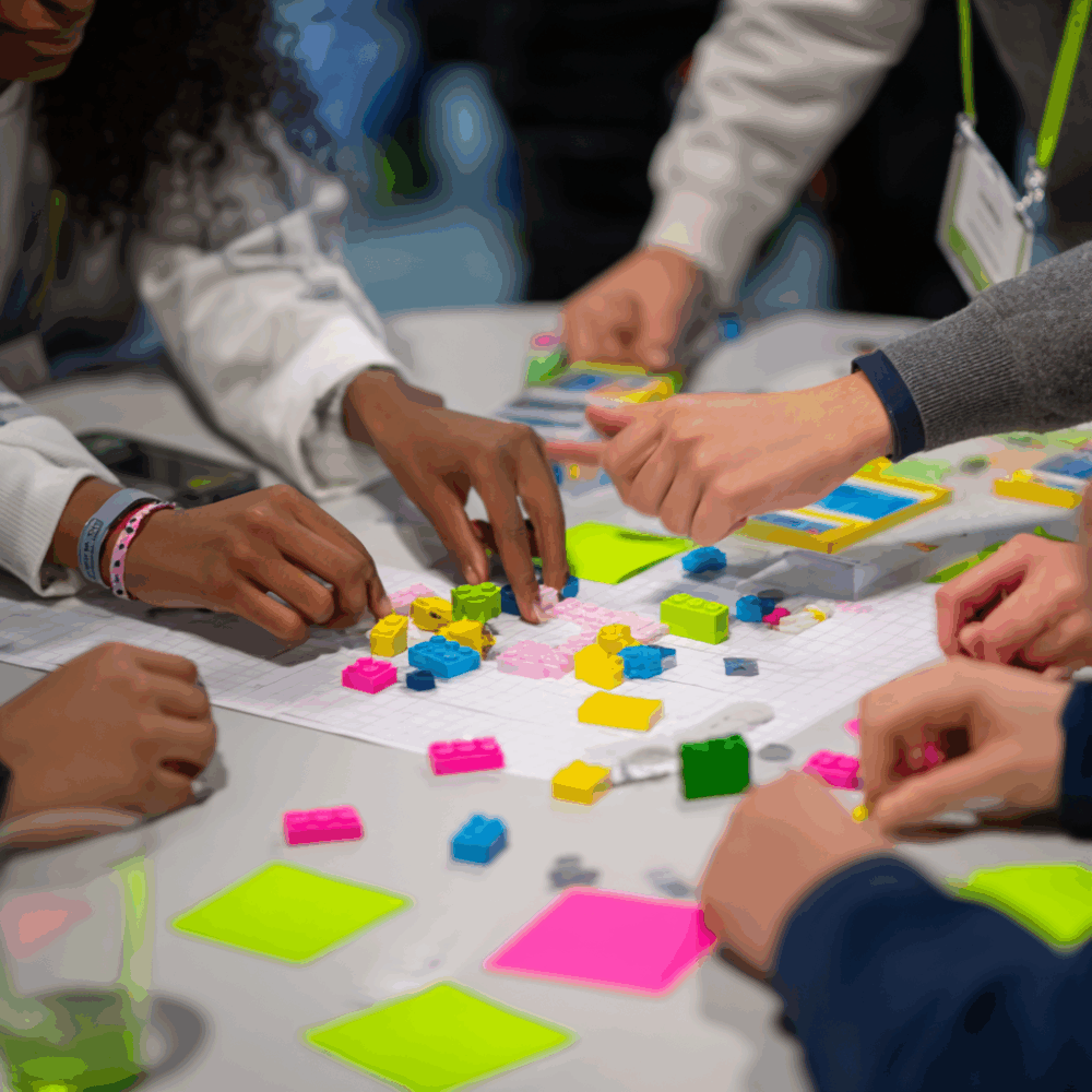 Hände, Bauklötze und Sticky Notes auf weißem Tisch im Büro